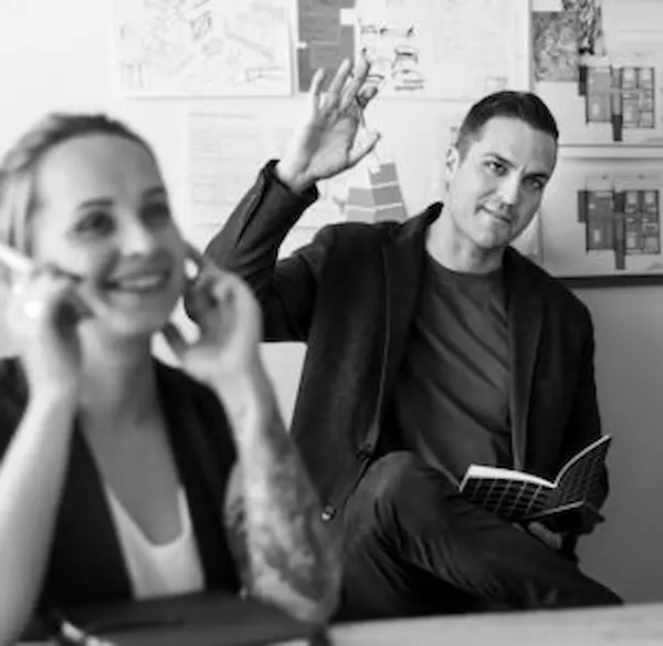 as a freelance digital marketing specialist in calicut A black and white photo of one man raising his hand in a meeting section.